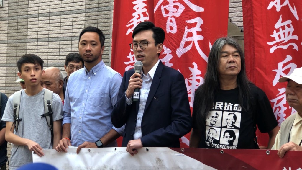 吳文遠（持咪者）與其支持者於開庭前高叫「梁振英禍港可恥」等口號。邱嘉幸 攝