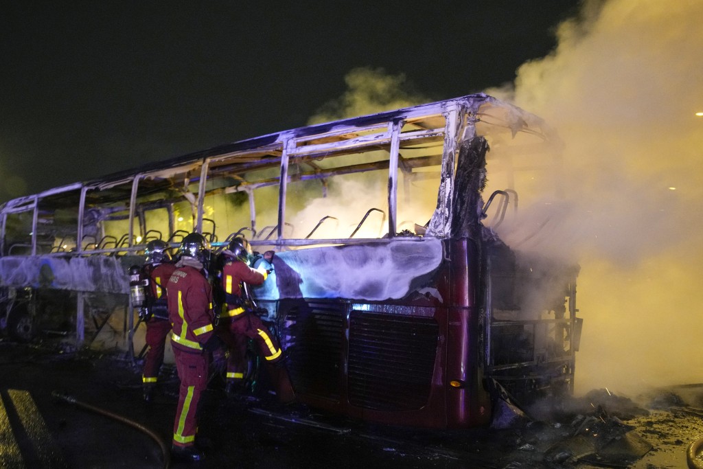 消防員向一輛燒毀的巴士噴水。路透社