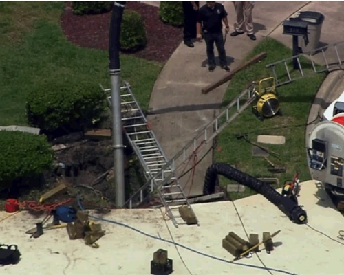 消防员赶到现场尝试用工具移走石屎块。网图