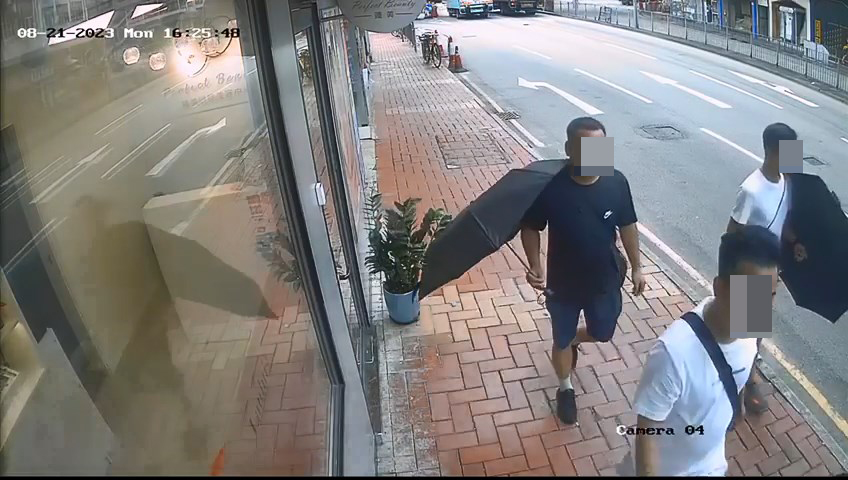 3名男子手持雨伞作遮掩，企图打开前方女子的背囊盗窃。
