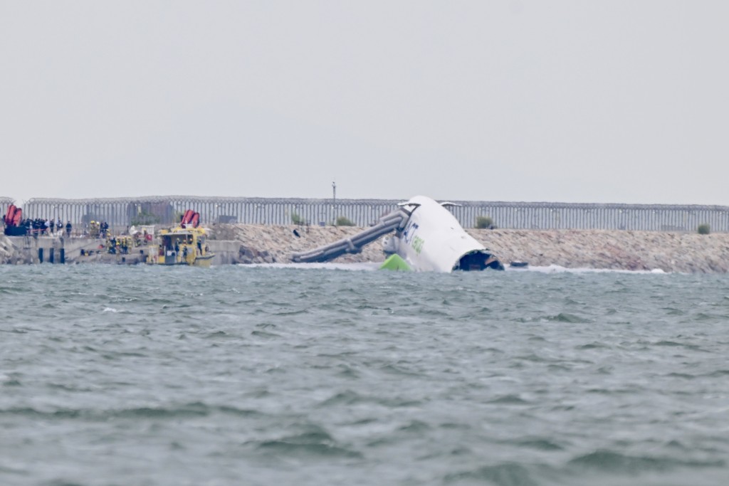 墮海客機擱在防波堤。 墮海客機擱在防波堤。