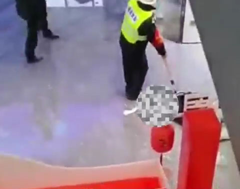 一保安员使用防爆叉，将行凶男子按在地上。网图