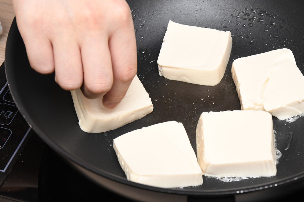 Step 5: 鑊內燒熱油，將豆腐煎至金黃，盛起。Heat oil in a pan. Fry the tofu until golden brown, remove.