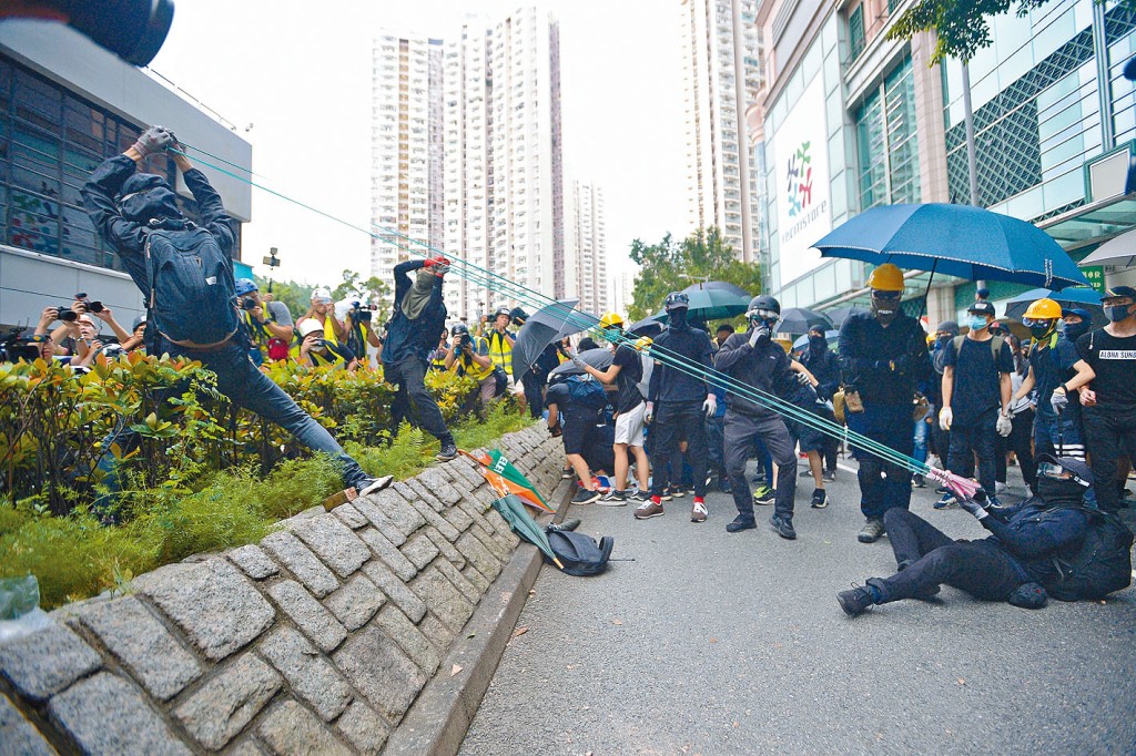 將軍澳遊行部分示威者,向將軍澳警署彈射石塊。