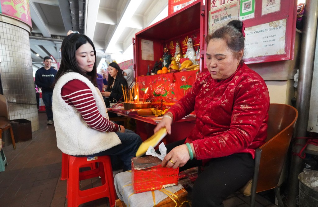 神婆手持舊鞋,用力拍打紙張,驅趕小人。 神婆手持舊鞋,用力拍打紙張,驅趕小人。