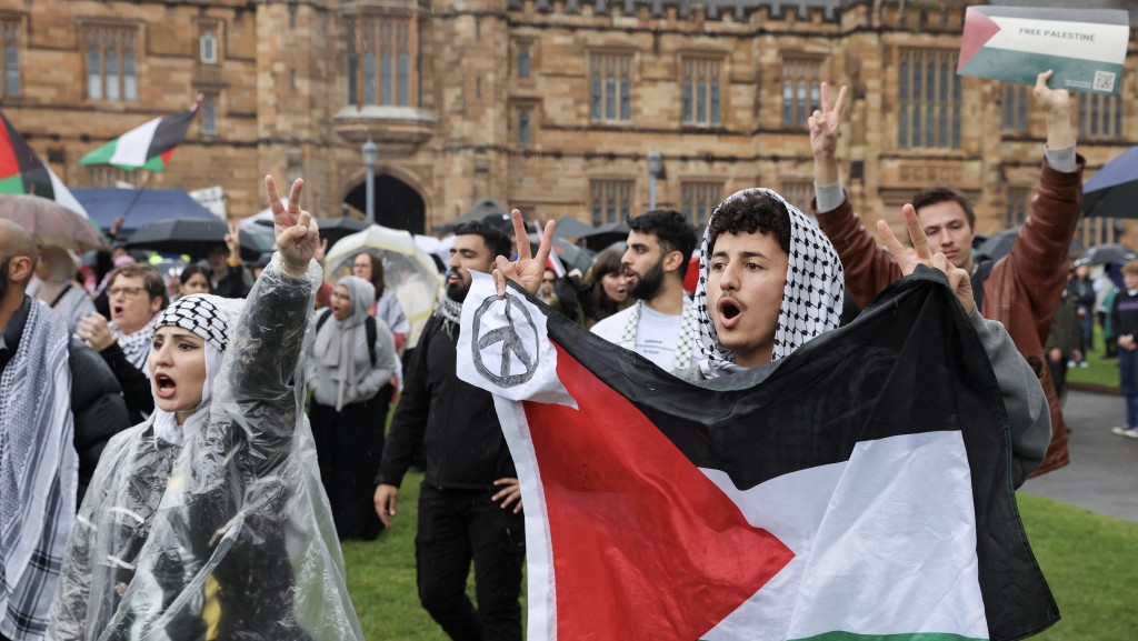 雪梨大學示威者手持巴勒斯坦旗與和平符號。 路透社