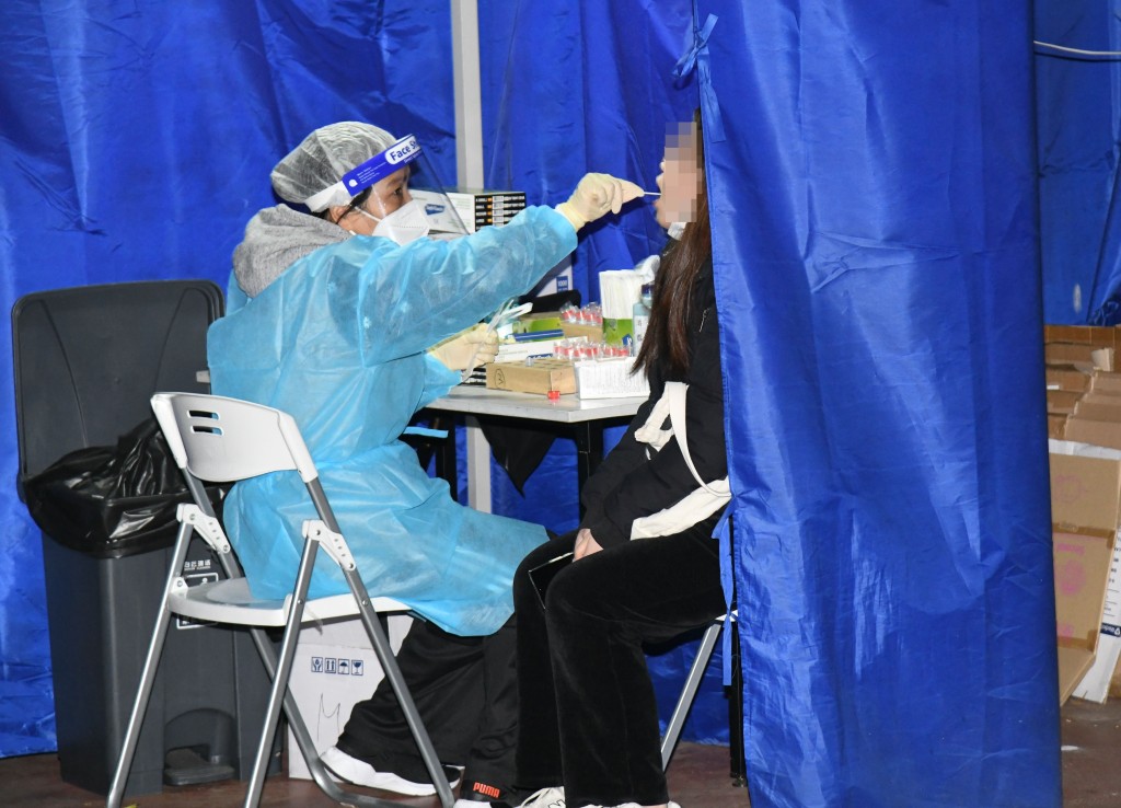 檢測站工作人員替巿民進行核酸檢測。