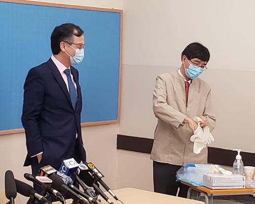 袁國勇(右)及林正財(左)下午到皇仁書院的檢測中心親身示範拭子採樣和深喉唾液採樣。