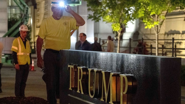 酒店易工後，工人準備拆除正門前的特朗普標誌。AP圖片