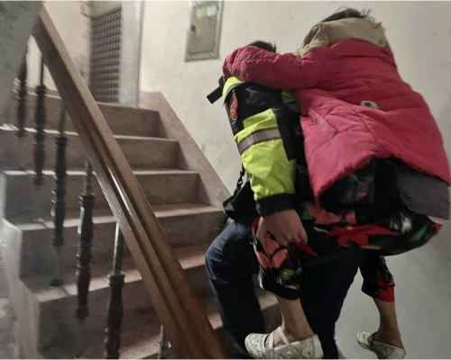 台灣警員主動揹老婦回4樓的住所。台灣警方圖片
