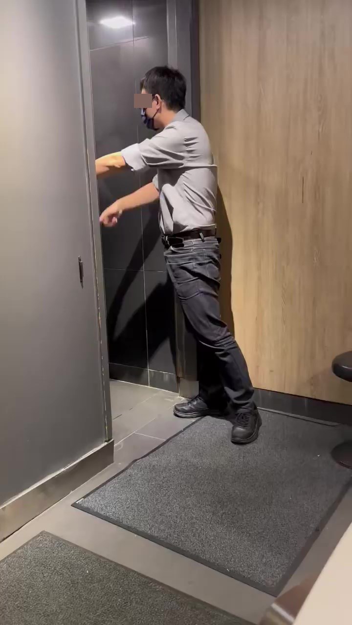 经理顶著男厕大门，以普通话劝喻内里的女子离开。网上截图