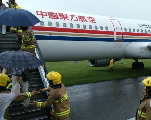 中國東方航空客機著陸衝出跑道，消防到場戒備。讀者提供