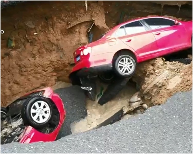 兩輛紅色私家車瞬間墜入深坑。