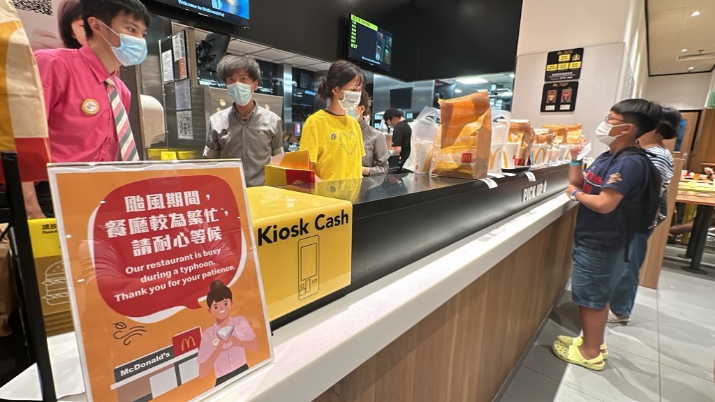 麥當勞康城分店打颱風下大收旺場，店內貼告示呼籲食客耐心等候。(劉漢權攝)