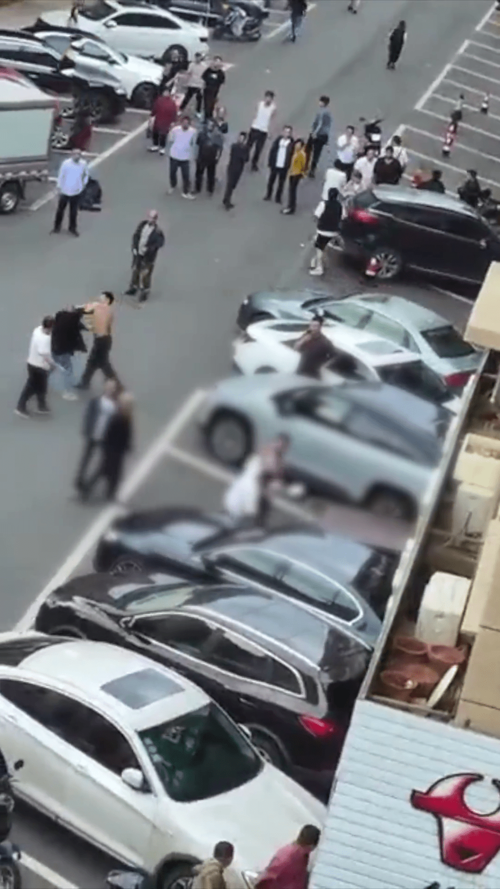 持刀者追到踢他的男子，对方在汽车旁对持。