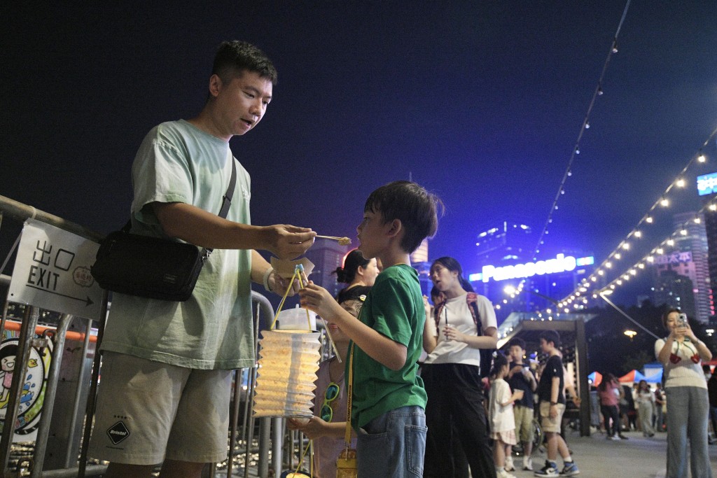 市民即場購買小食後與孩子一同分享。陳浩元攝