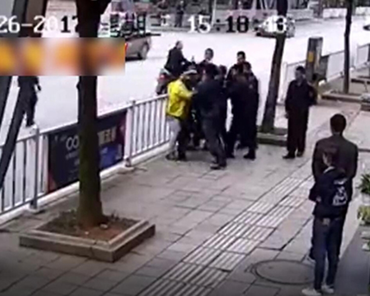 一名城管隊員上前將其攔住,另外8名城管隊員把送餐的車推走。