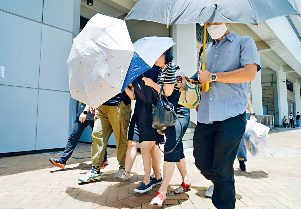 被告梁嘉儀（右三）昨日由友人陪同下離開法院。