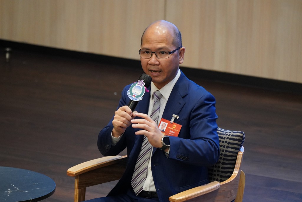 港區全國人大代表、選委界議員黃錦良向同事解說政府工作報告的重點數據。 港區全國人大代表、選委界議員黃錦良向同事解說政府工作報告的重點數據。