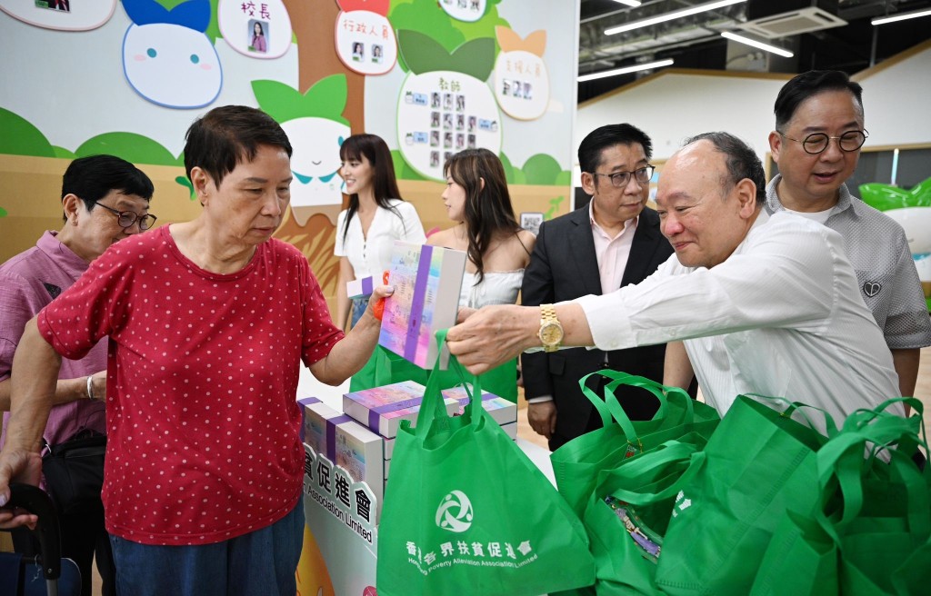 香港各界扶贫促进会主席苏长荣等人向街坊派发月饼及礼品包。