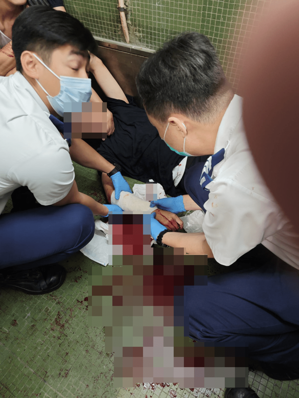 一名戴眼鏡的關員倒卧地上,右手中刀流血。網上圖片 一名戴眼鏡的關員倒卧地上,右手中刀流血。網上圖片