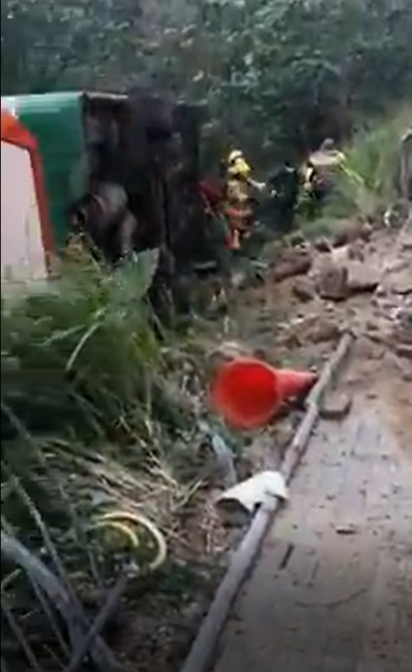 消防员主动走入草丛与泥泞中为乘客解救，并安全辅助他们重返行人路边。(网片截图)