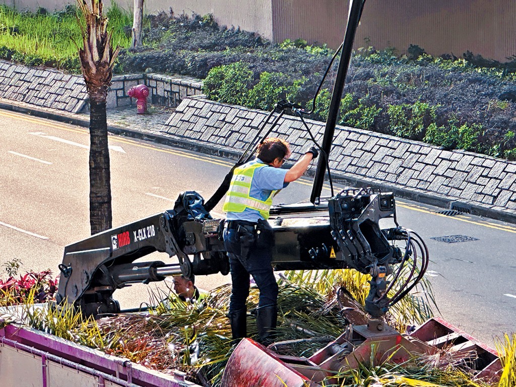 警員爬上吊車車斗,協助將吊臂與架空電纜分開。