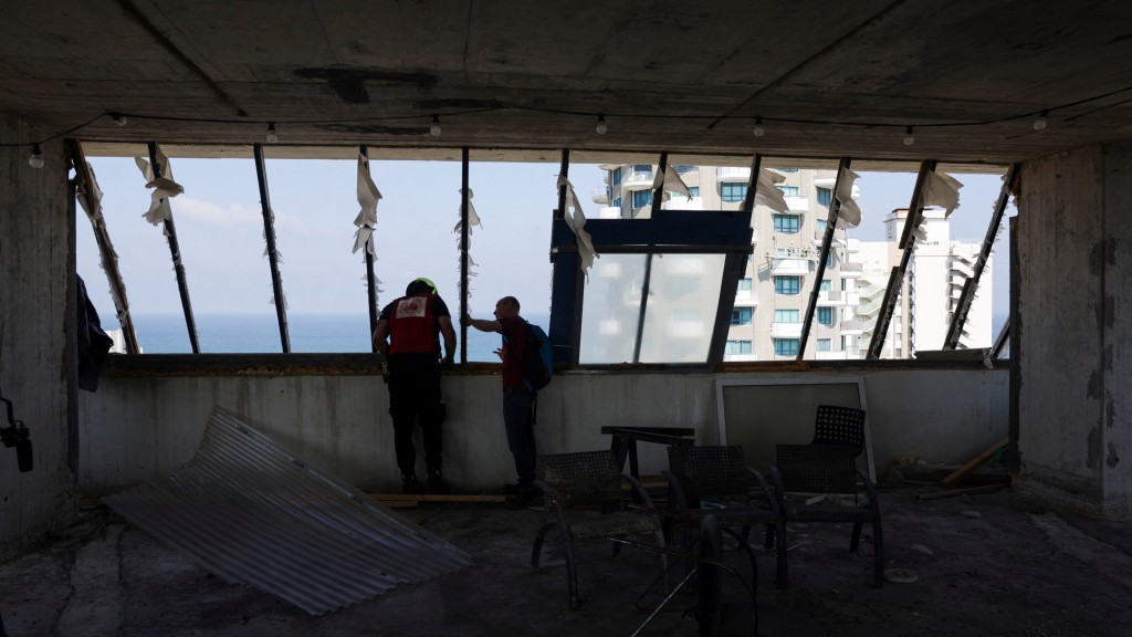 以色列消防及救护部门检查建筑物受损程度。 路透社