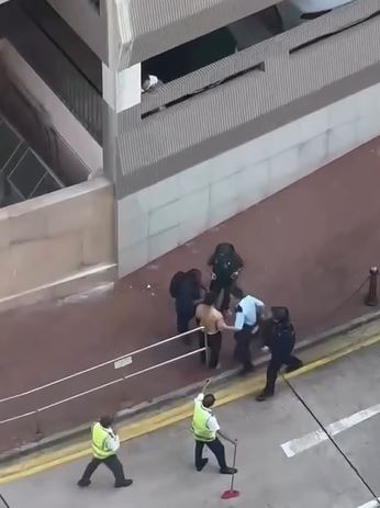 疑兇被制服後，遭數名警員包圍。網片截圖