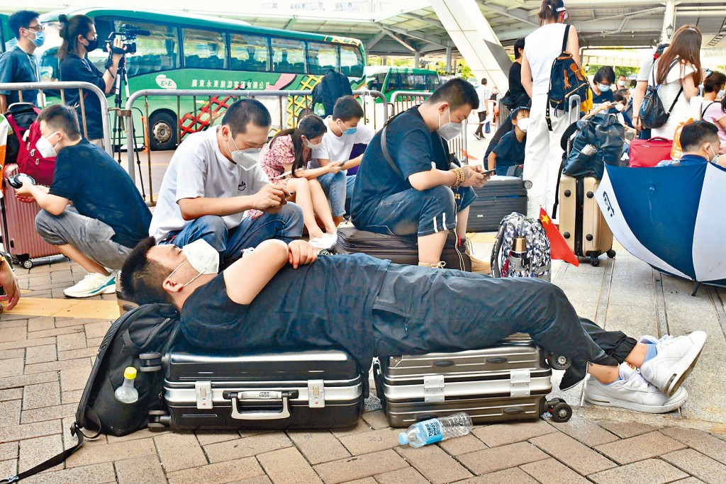 深圳灣口岸連日過關者眾，有旅客用兩個大篋作牀小睡片刻。 