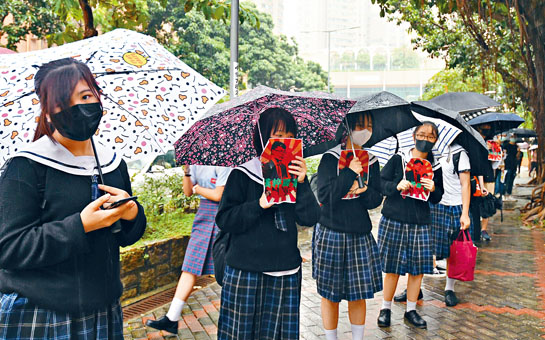逾二十名學生與數十名自稱校友昨響應網上號召，冒雨在校門外築成人鏈抗議。