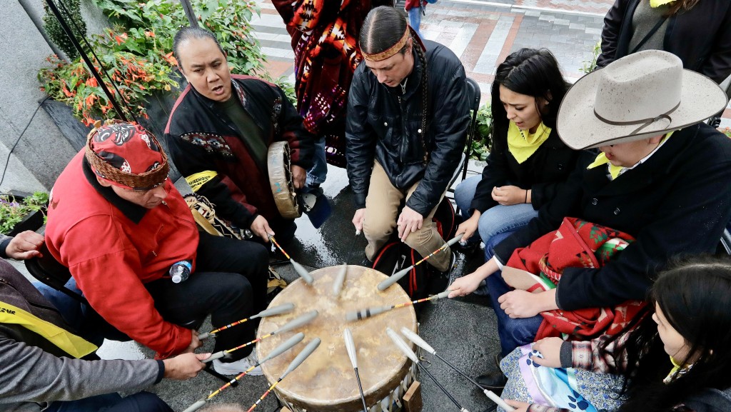 在原住民日祝福和游行前集会期间，美洲原住民和第一民族一起打鼓。 美联社