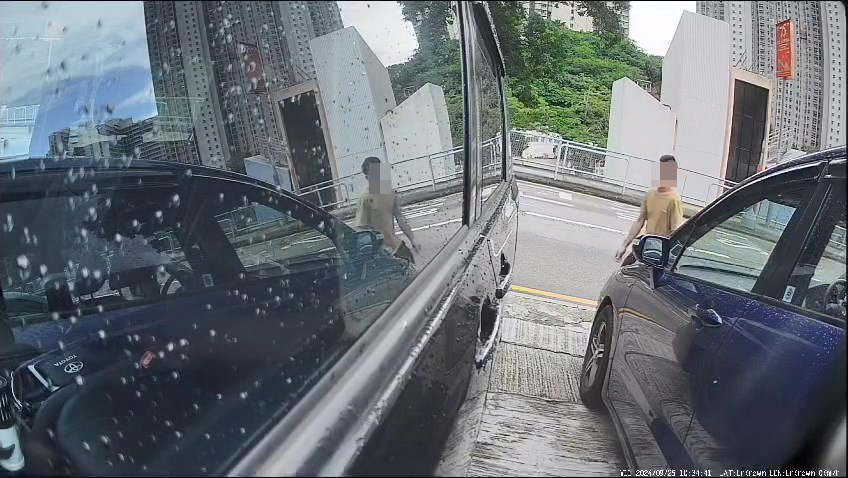 一名中年男子日前走入兩車之間的車罅。網上片段截圖