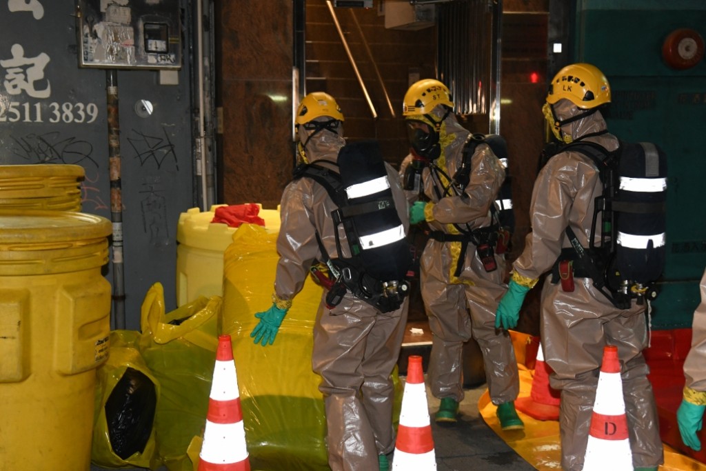 消防人员穿上核生化防护袍及戴上呼吸器进入大厦内。李家杰摄