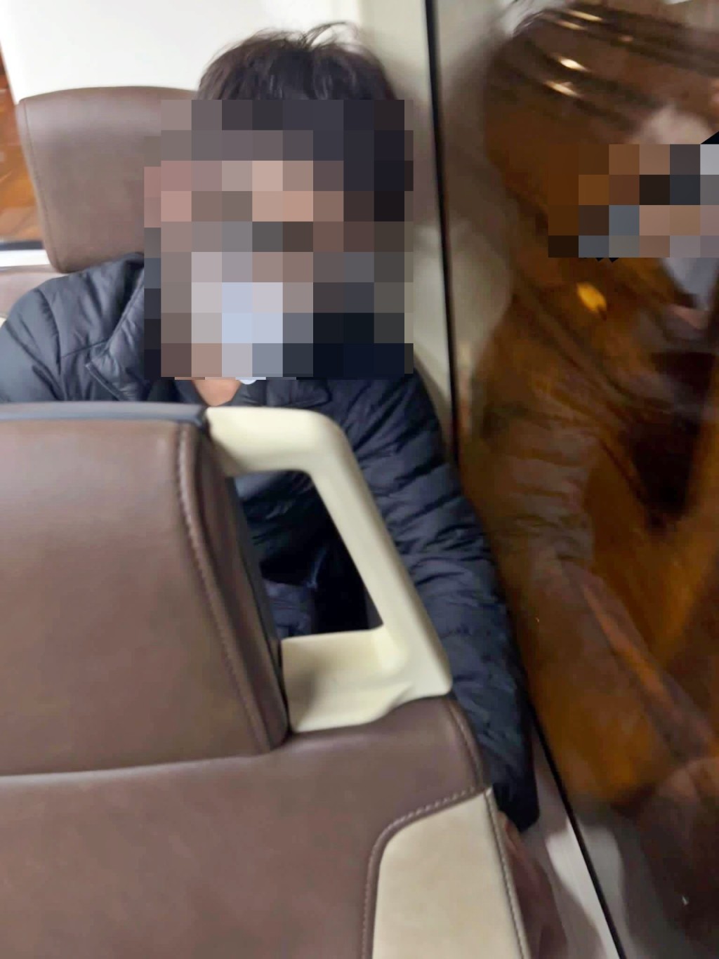 一名坐后排左边的黑衣男乘客，沿窗边伸长左手。网图