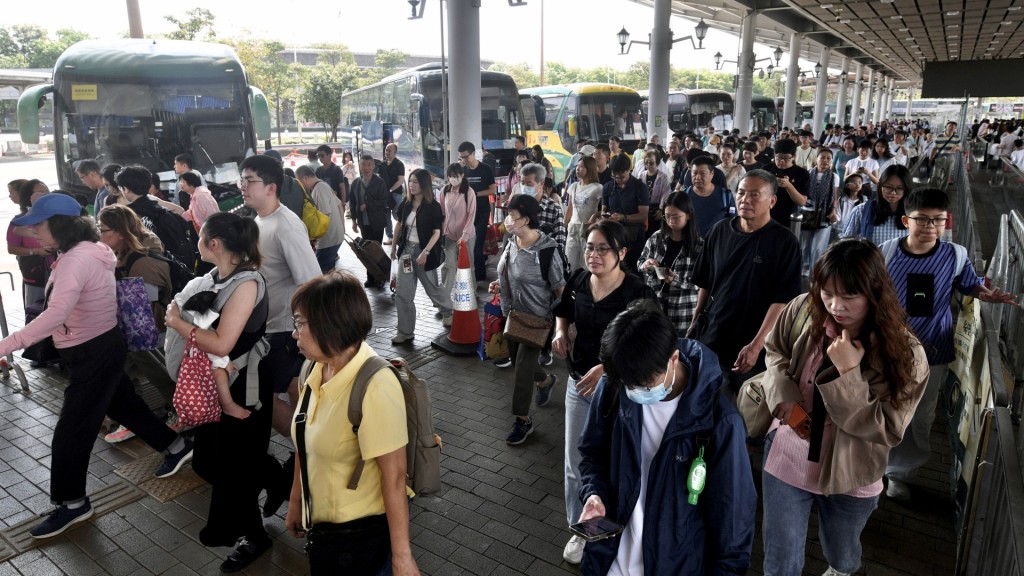 大批旅客排隊等候巴士出市區。