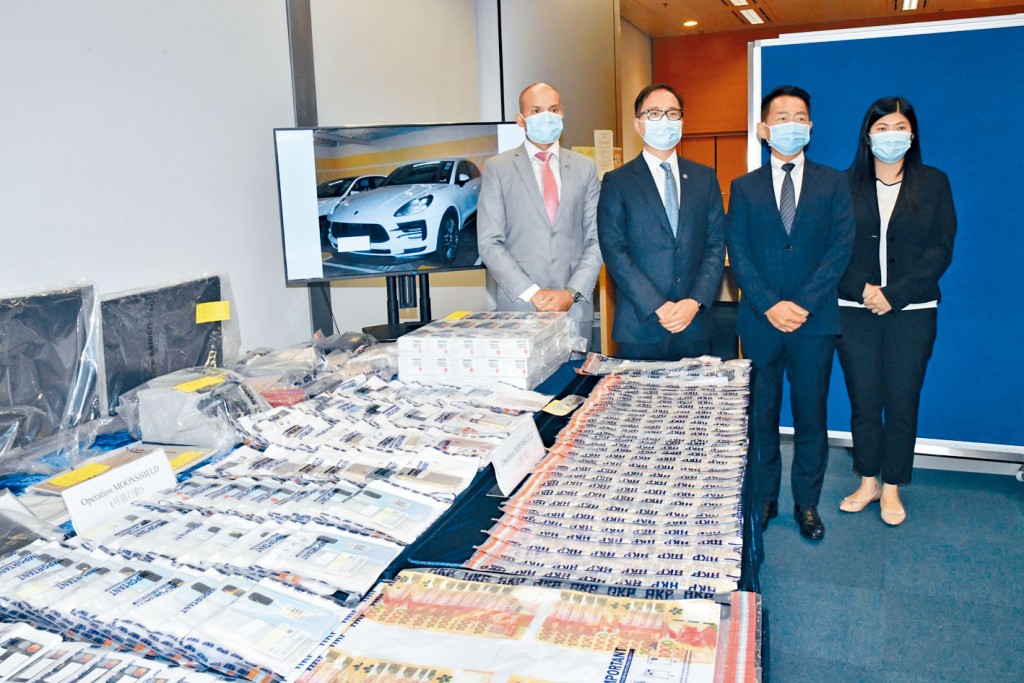 總警司羅越榮(左二)講述案情及展示行動中檢獲現金與名表等證物。