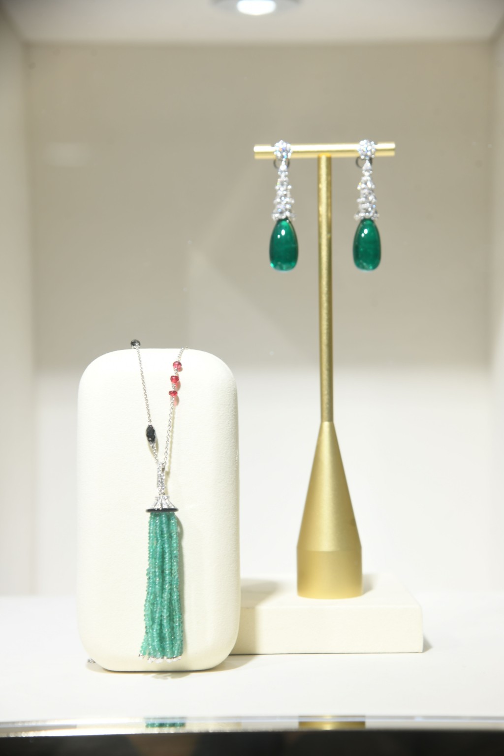 品牌的高級珠寶系列中，以鑲嵌綠寶石最為耀眼，這條項鏈與耳環簡單卻高貴。