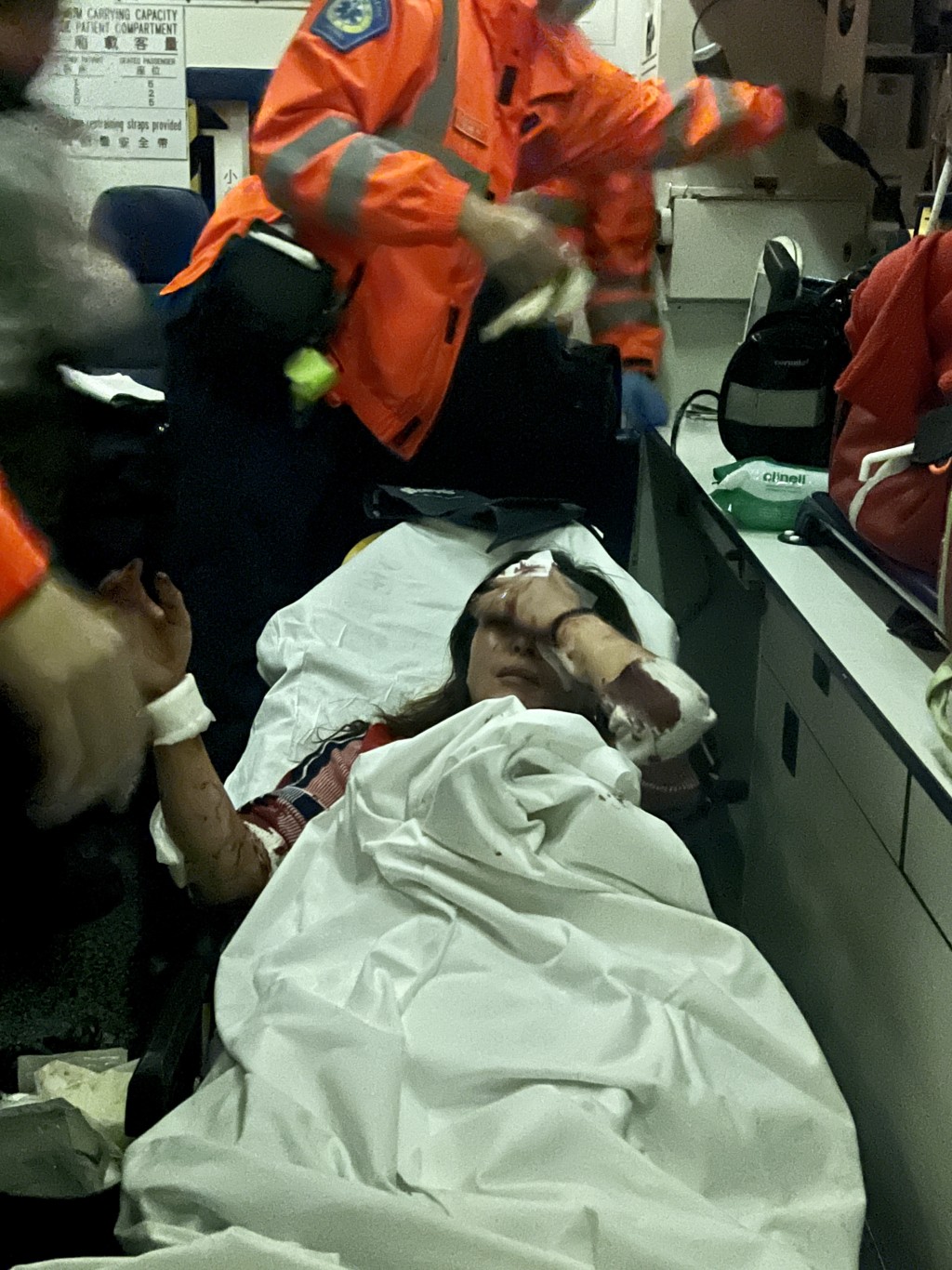 女伤者额头、面及手部中刀浴血，由救护车送院。李家杰摄