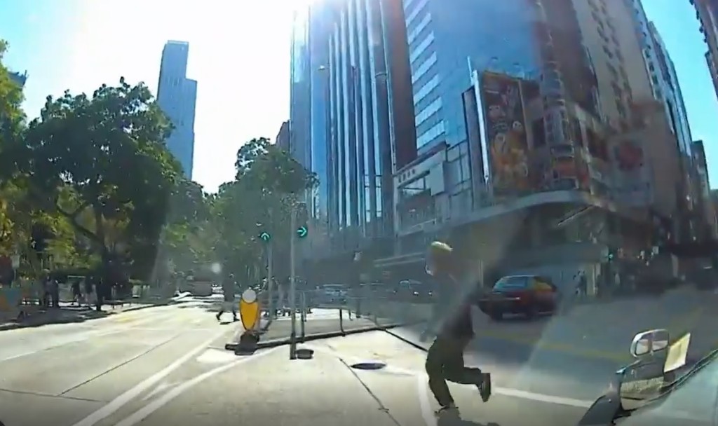 男途人越過轉入金馬倫道的兩線行車路時，的士司機連忙慢車。（影片截圖）