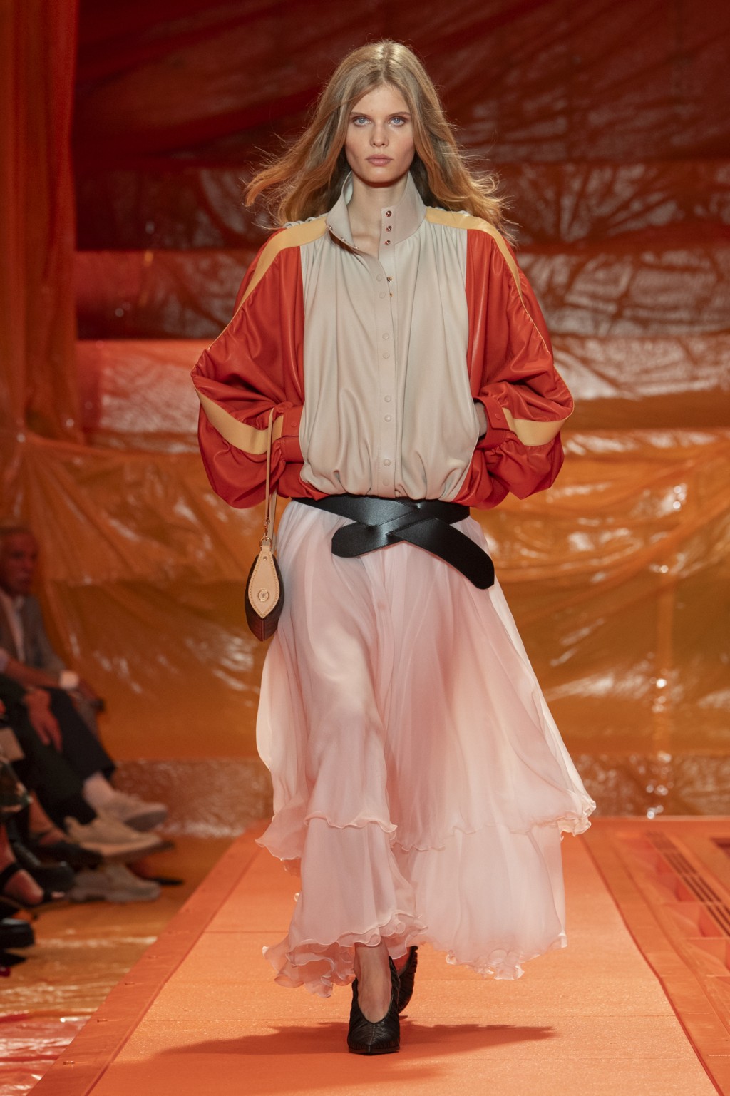 )Louis Vuitton 寬身又帶點復古色彩的外套，下襯襬裙以不規則剪裁的輕柔粉色半截長裙，展現休明的巴黎時尚格調。