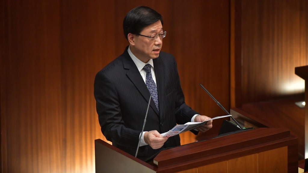 李家超回應議員提問時，拿出一份報紙引述內容。陳極彰攝