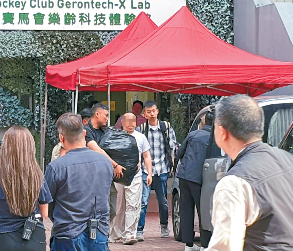 方在嶺大宿舍調查,探員將一名白衫男子及一袋證物帶上車。