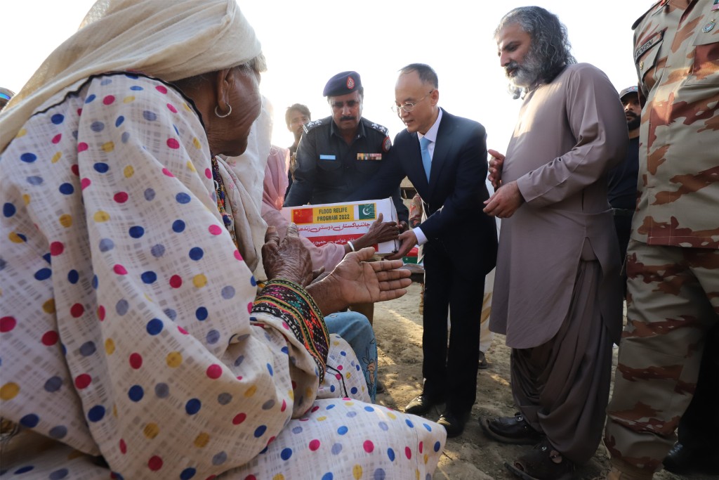 2022年9月11日，中国驻巴基斯坦大使农融（中）向当地灾民发放中国援助的物资。（新华社）