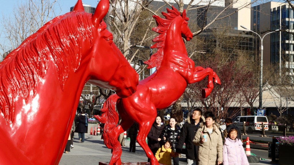 北京西單商圈擺放紅馬藝術裝置吸引民眾。中新社