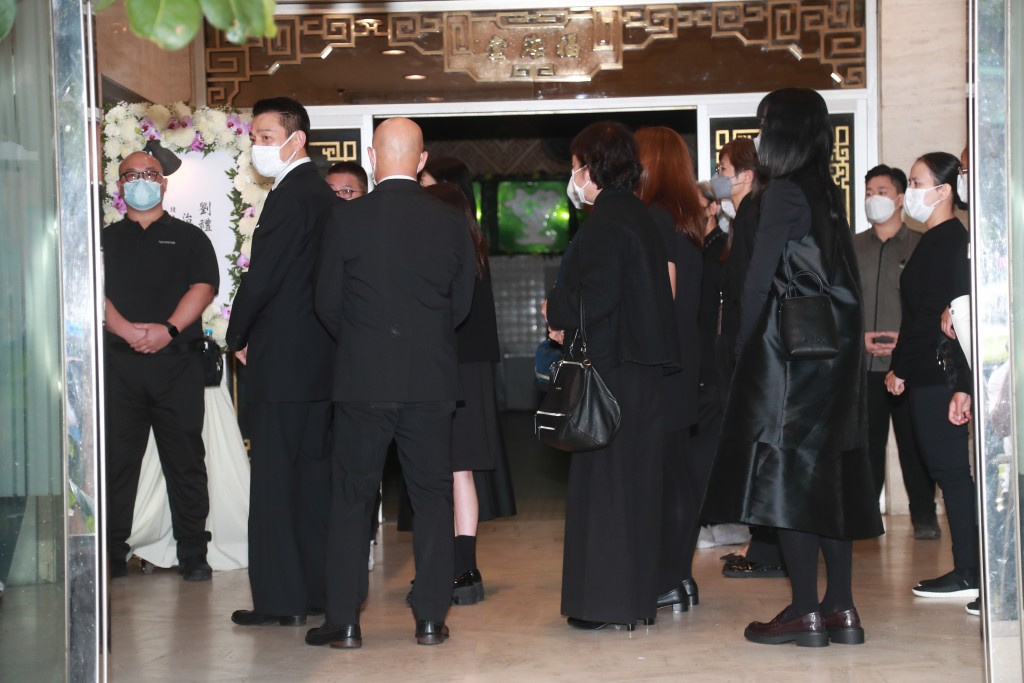 刘德华背着殡仪馆内的传媒，似刻意用人墙包围着女儿及太太尽量避开传媒镜头。