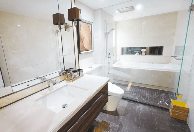 圖中浴室以淺色作主調，浴缸背牆以雲石作襯托，感覺清雅。