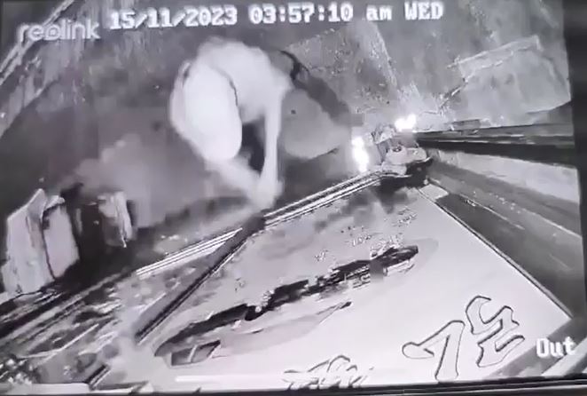 鴨舌帽男子用硬物砸爆地產舖玻璃。閉路電視片段截圖