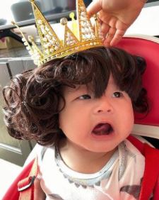 外婆把乖孫扮成攣毛小國王。