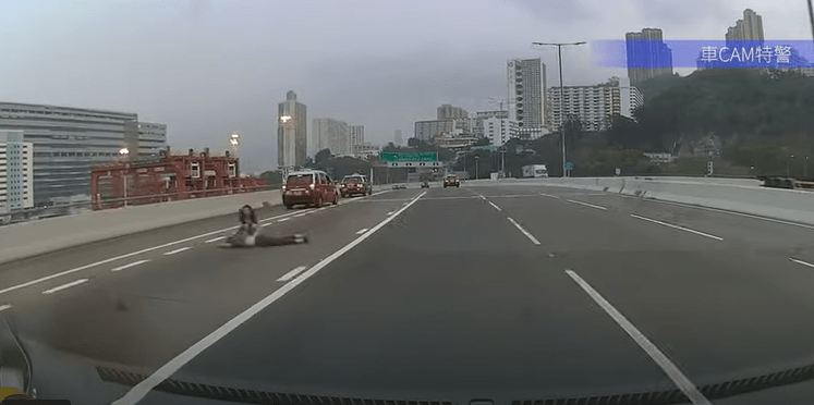 車CAM拍得跳車青年伏在公路上，女友在旁安慰。車ＣＡＭ截圖